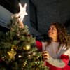 Weihnachten alleine feiern Frau schmückt Weihnachtsbaum