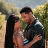 Anna (Halle Bailey) und Michael (Regé-Jean Page) sind die Hauptrollen in „You, Me & Italy“. Eine Frau mit langen dunklen Haaren und ein Mann mit dunklen Haaren stehen auf einem Weinberg und schauen sich innig an.