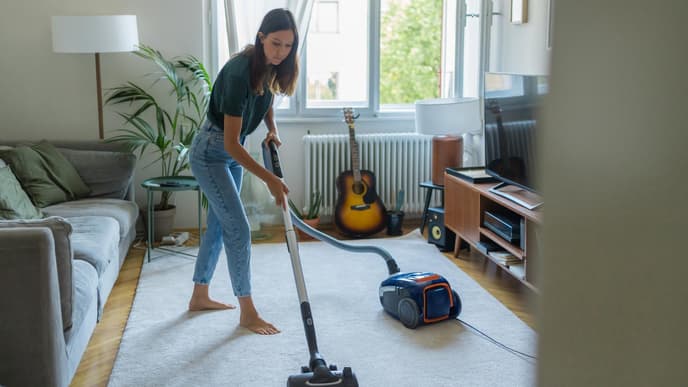 Frühjahrsputz Checkliste Frau saugt das Wohnzimmer