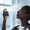 Frau sprüht Face Mist auf Frau sprüht Face Mist auf